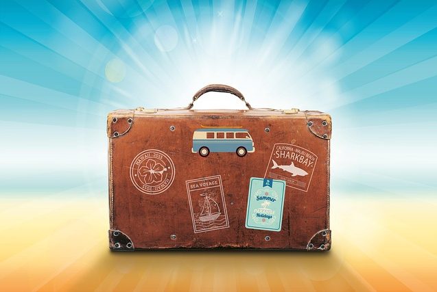 Reisekoffer am Strand vor Sonnenstrahlen